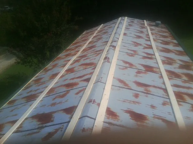 Rusted metal roof panels with new wood purlins before replacement — Storm Damage Roof Repair in Morrison by Roofing Brothers