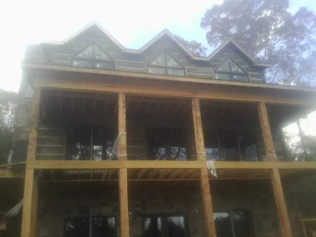 Dormers and porch framing on a large log home under construction — Roof Coating work by our crew in Morrison