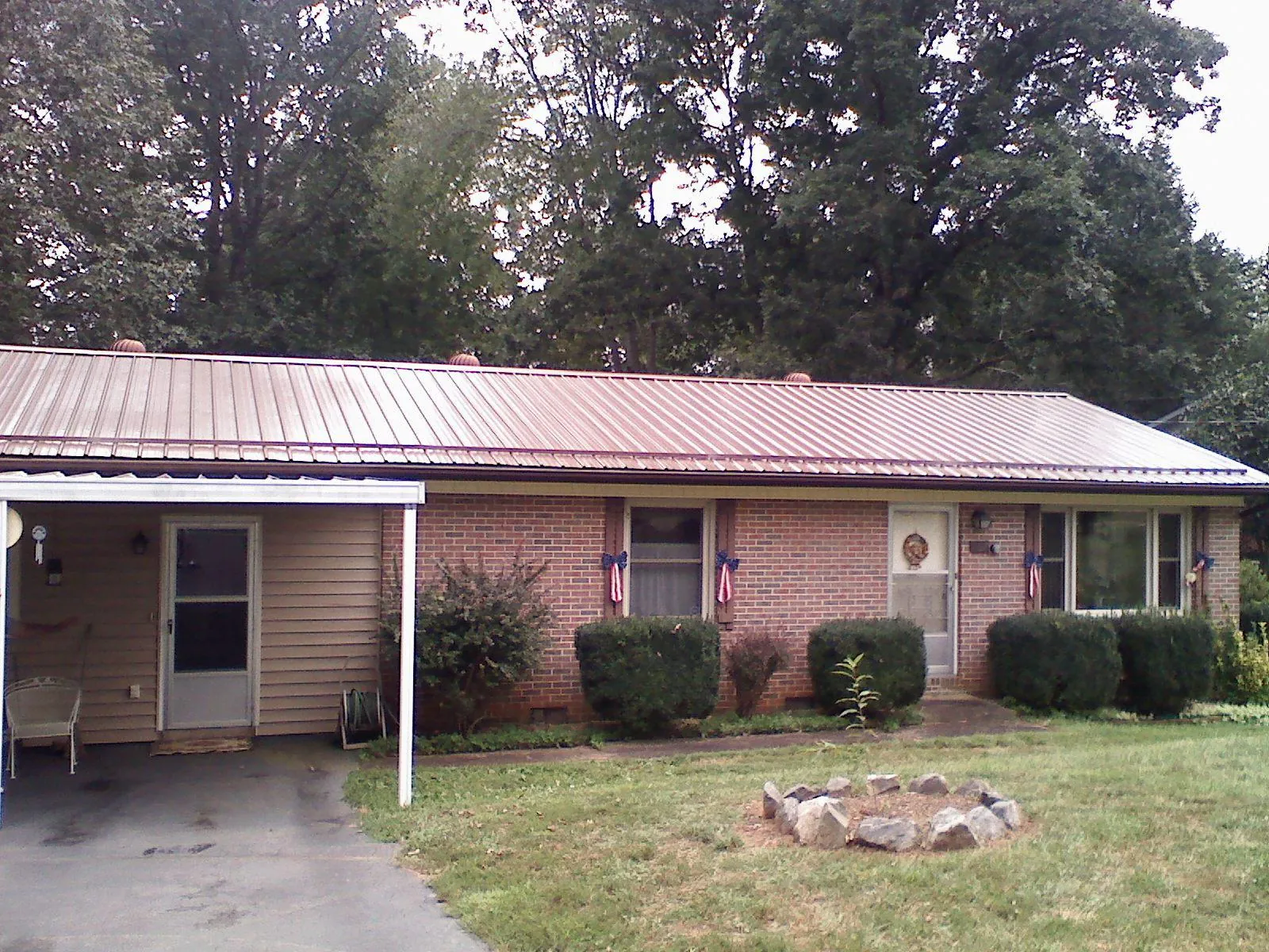 Bronze metal roof and carport on a brick ranch home — Roof Repair work by our crew in Morrison